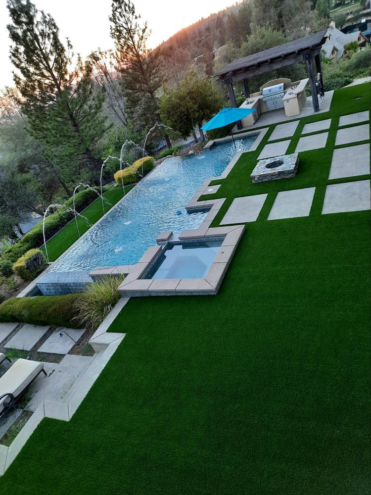 Synthetic grass installation with pool and coping.