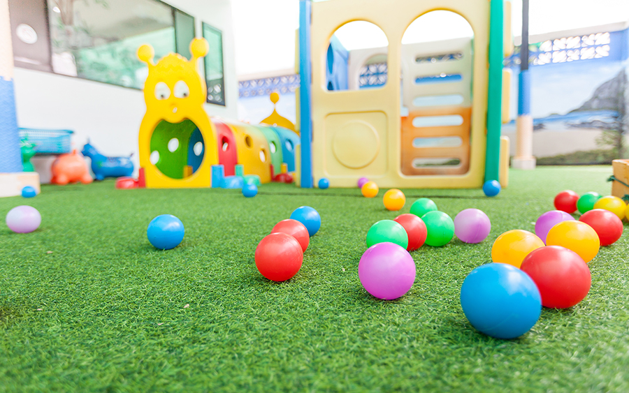 Plastic balls resting on artificial grass playground.