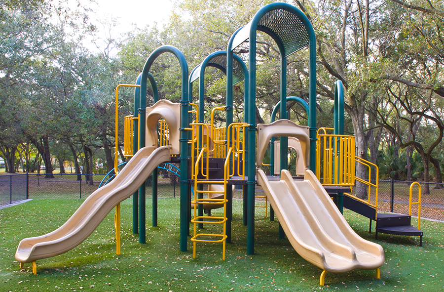 Childrens Playground in backyard with artificial grass surface.