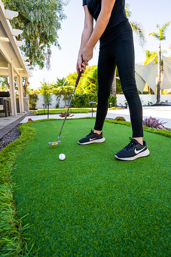 Artificial grass putting green in backyard.