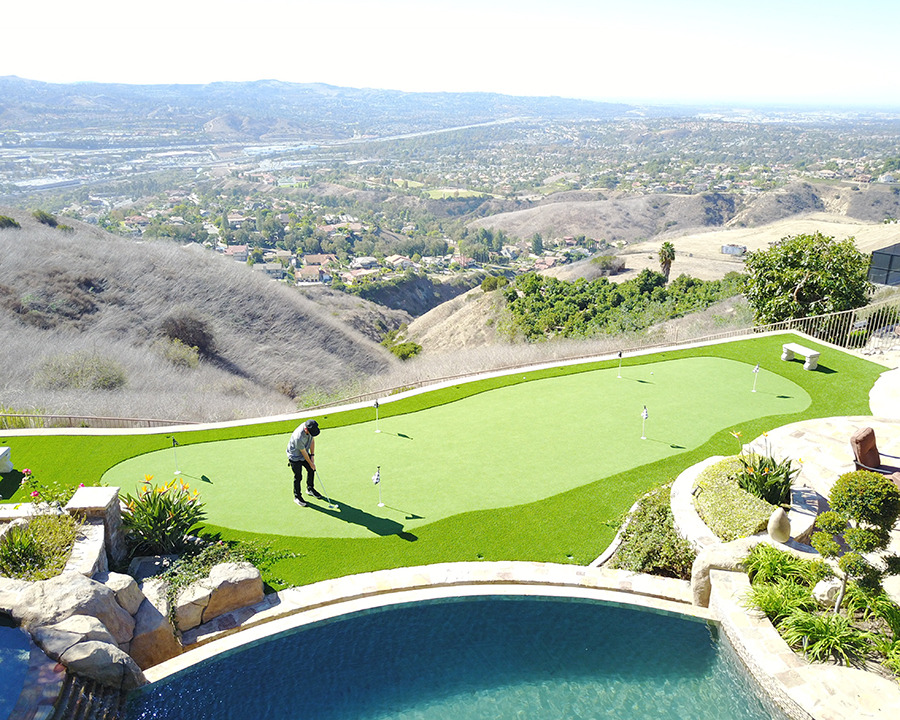 Overhead shot of someone practicing their short game on synthetic grass putting green.